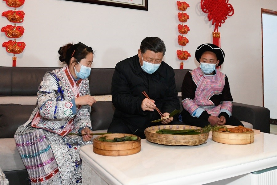 2021年2月3日下午，習(xí)近平在貴州畢節(jié)市黔西縣新仁苗族鄉(xiāng)化屋村苗族村民趙玉學(xué)家，同一家人邊聊家常邊制作當(dāng)?shù)貍鹘y(tǒng)節(jié)日食品黃粑。新華社記者 李學(xué)仁 攝