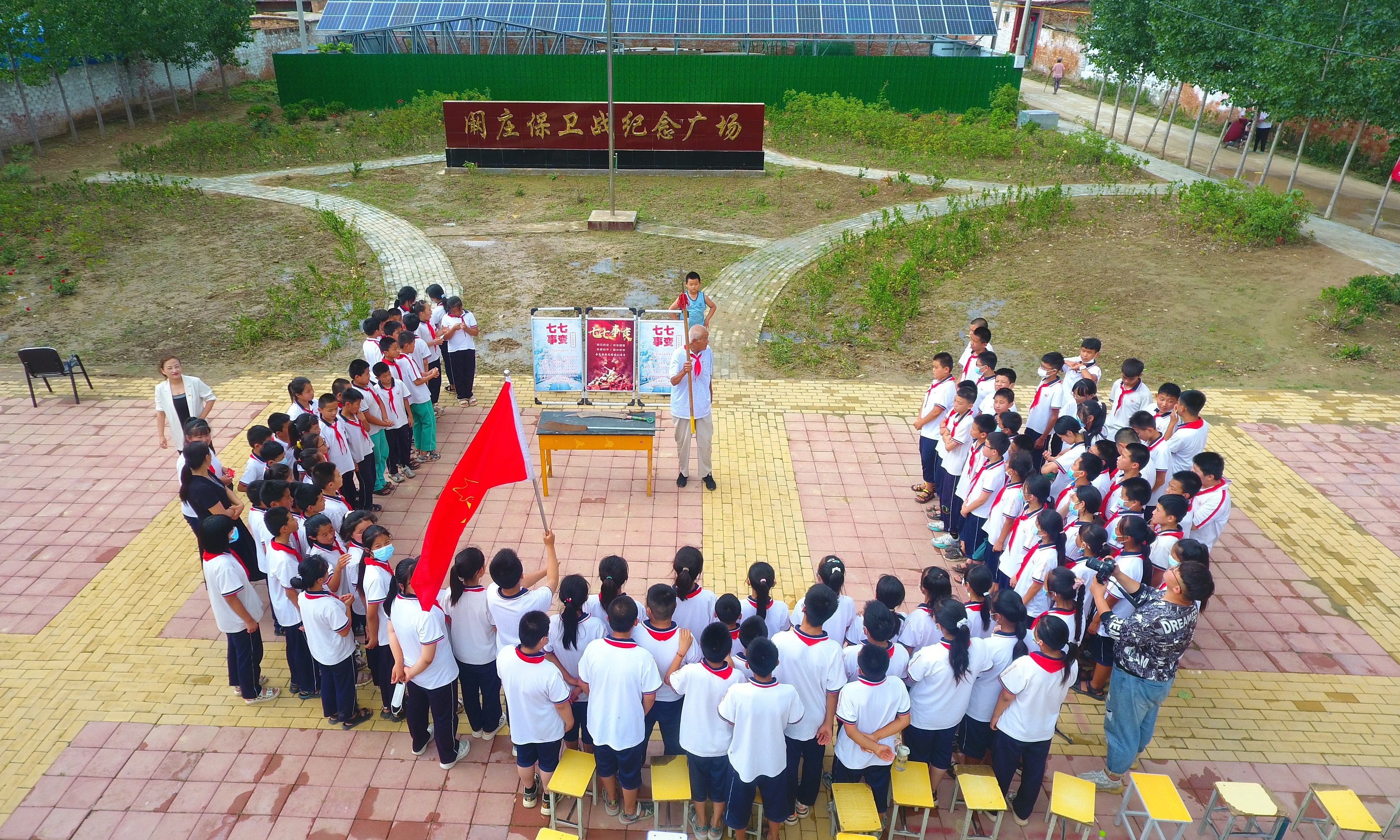 2022年7月6日，山東省聊城市，在茌平區(qū)菜屯鎮(zhèn)闞莊村的闞莊保衛(wèi)戰(zhàn)紀(jì)念廣場，闞莊保衛(wèi)戰(zhàn)親歷者王光木老人，為小學(xué)生們講述抗戰(zhàn)故事，展示大刀、長矛。
