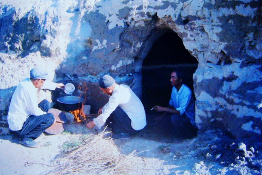 1983年，“六老漢”一代治沙人在“地窩子”生活做飯。新華社發(fā)（八步沙林場(chǎng)供圖）